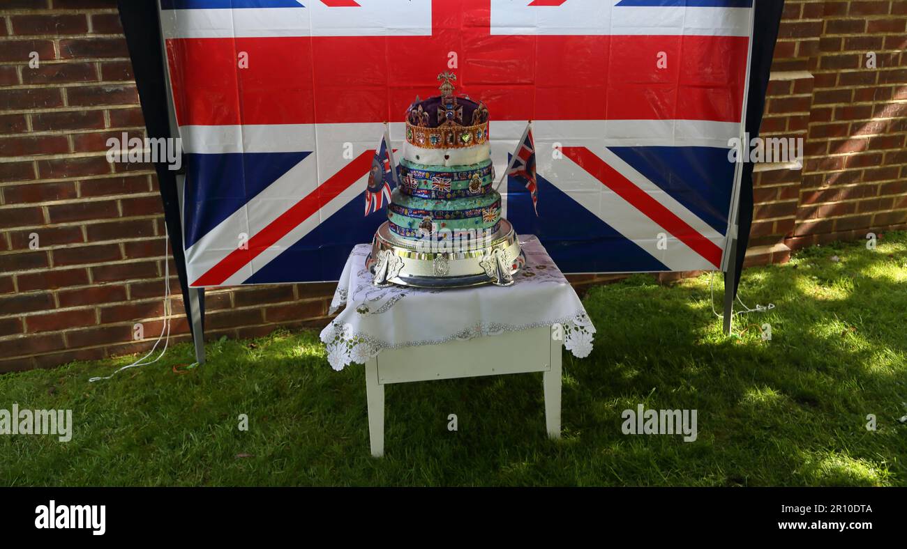 Gâteau couronné à plusieurs niveaux devant le drapeau Union Jack à Street Party célébrant le Roi Charles III Coronation Surrey Angleterre Banque D'Images