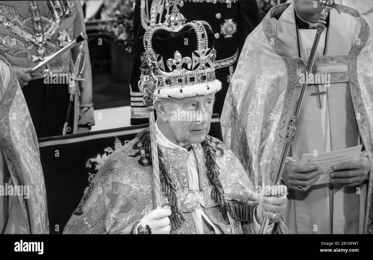 Le roi Charles III portant la couronne Saint-Édouard, tenant le Scepter du souverain avec la Croix et le Scepter avec Dove, assis dans la chaise de couronnement de 727 ans, qui a été utilisée pendant le couronnement de 26 monarques anglais au cours des sept derniers siècles. Ici, le roi Charles III a été officiellement déclaré roi pendant son couronnement par l'archevêque de Cantebury Justin Welby. Westminster Abbey Westminster Londres ( Black and White rétro alt. traitement) Banque D'Images