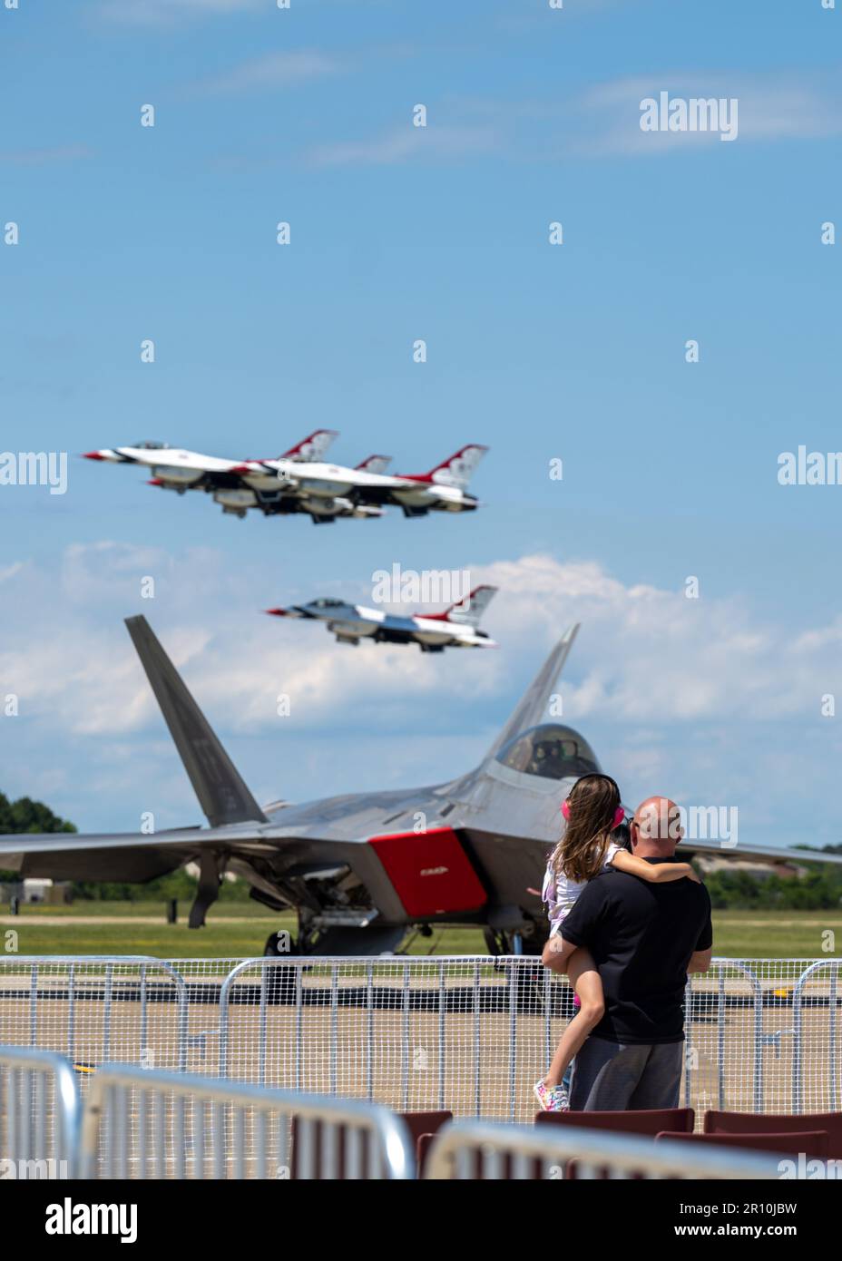 Une fille et son père regardent les États-Unis Les Thunderbirds de la Force aérienne se présentent pendant le spectacle aérien, Air Power Over Hampton Roads, à la base conjointe Langley-Eustis, en Virginie, en 6 mai 2023. L’APOHR a été mis sur le marché pour inspirer les préposés et engager la communauté locale, en présentant la plate-forme de projection de puissance de l’Amérique ici à Hampton Roads. (É.-U. Photo de la Force aérienne par Anna Nolte, un homme d'aviation principal) Banque D'Images