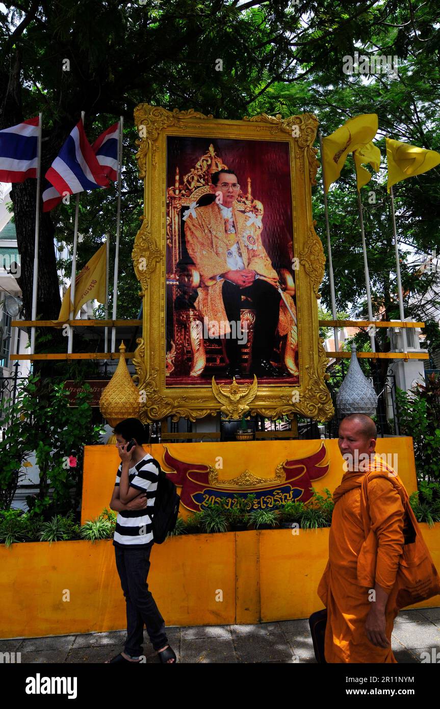 Les gens du coin marchent sur une photo du roi Bhumibol Adulyadej de Thaïlande. Bangkok, Thaïlande. Banque D'Images