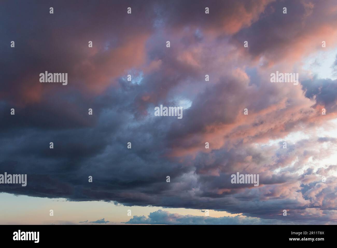 Contexte : la nature étonnante et spectaculaire moody rose, violet et bleu ciel coucher de soleil nuageux tourné à la verticale. Banque D'Images