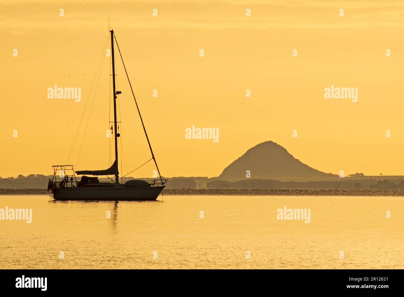 Portobello, Édimbourg, Écosse, Royaume-Uni. 11 mai 2023. Soleil lent à apparaître sur la banque de nuages à l'horizon au Firth of Forth. Température de 7 degrés mais agréable sensation douce avec peu ou pas de brise. Photo : petit yacht de plaisance amarré à Firth of Forth avec la loi de Berwick en arrière-plan. Crédit : Arch White/alamy Live News. Banque D'Images