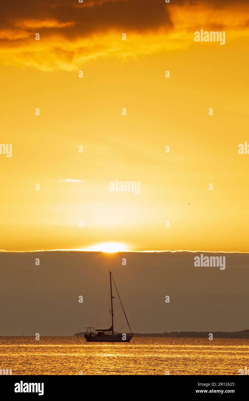 Portobello, Édimbourg, Écosse, Royaume-Uni. 11 mai 2023. Soleil lent à apparaître sur la banque de nuages à l'horizon au Firth of Forth. Température de 7 degrés mais agréable sensation douce avec peu ou pas de brise. Photo : petit yacht de plaisance amarré au Firth of Forth avec une banque de nuages à l'horizon qui obscurcit le soleil levant. Crédit : Arch White/alamy Live News. Banque D'Images