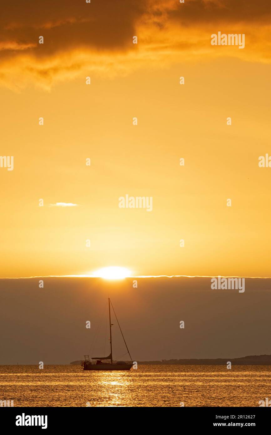 Portobello, Édimbourg, Écosse, Royaume-Uni. 11 mai 2023. Soleil lent à apparaître sur la banque de nuages à l'horizon au Firth of Forth. Température de 7 degrés mais agréable sensation douce avec peu ou pas de brise. Photo : petit yacht de plaisance amarré au Firth of Forth avec une banque de nuages à l'horizon qui obscurcit le soleil levant. Crédit : Arch White/alamy Live News. Banque D'Images