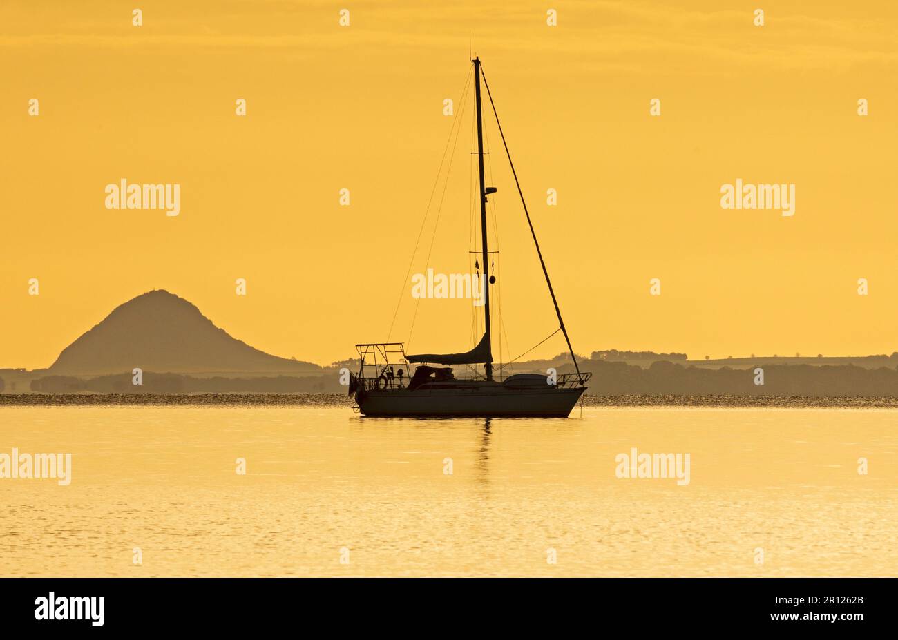 Portobello, Édimbourg, Écosse, Royaume-Uni. 11 mai 2023. Soleil lent à apparaître sur la banque de nuages à l'horizon au Firth of Forth. Température de 7 degrés mais agréable sensation douce avec peu ou pas de brise. Photo : petit yacht de plaisance amarré à Firth of Forth avec la loi de Berwick en arrière-plan. Crédit : Arch White/alamy Live News. Banque D'Images