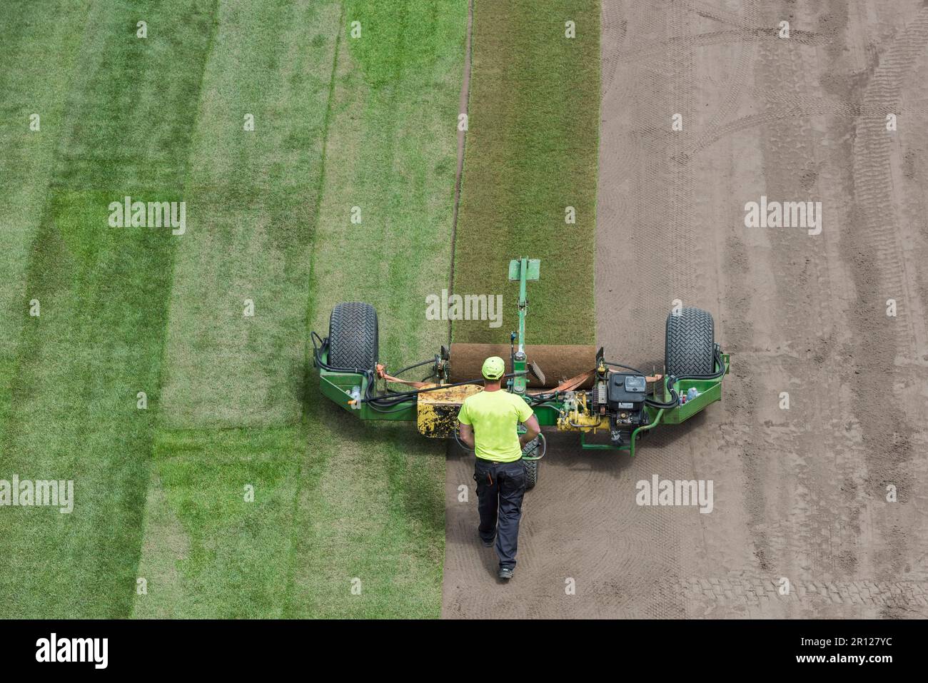 Les travailleurs qui ponent de l'herbe sur un terrain de football du stade. Banque D'Images
