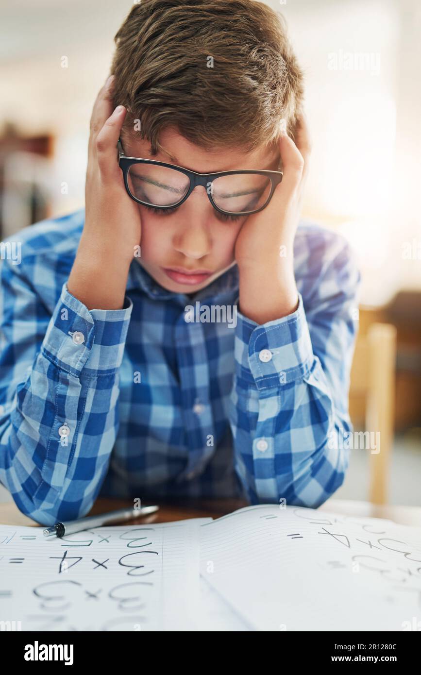 La messagerie instantanée est en difficulté. Portrait d'un jeune garçon qui a l'air stressé tout en étant assis à l'intérieur d'une salle de classe pendant la journée. Banque D'Images