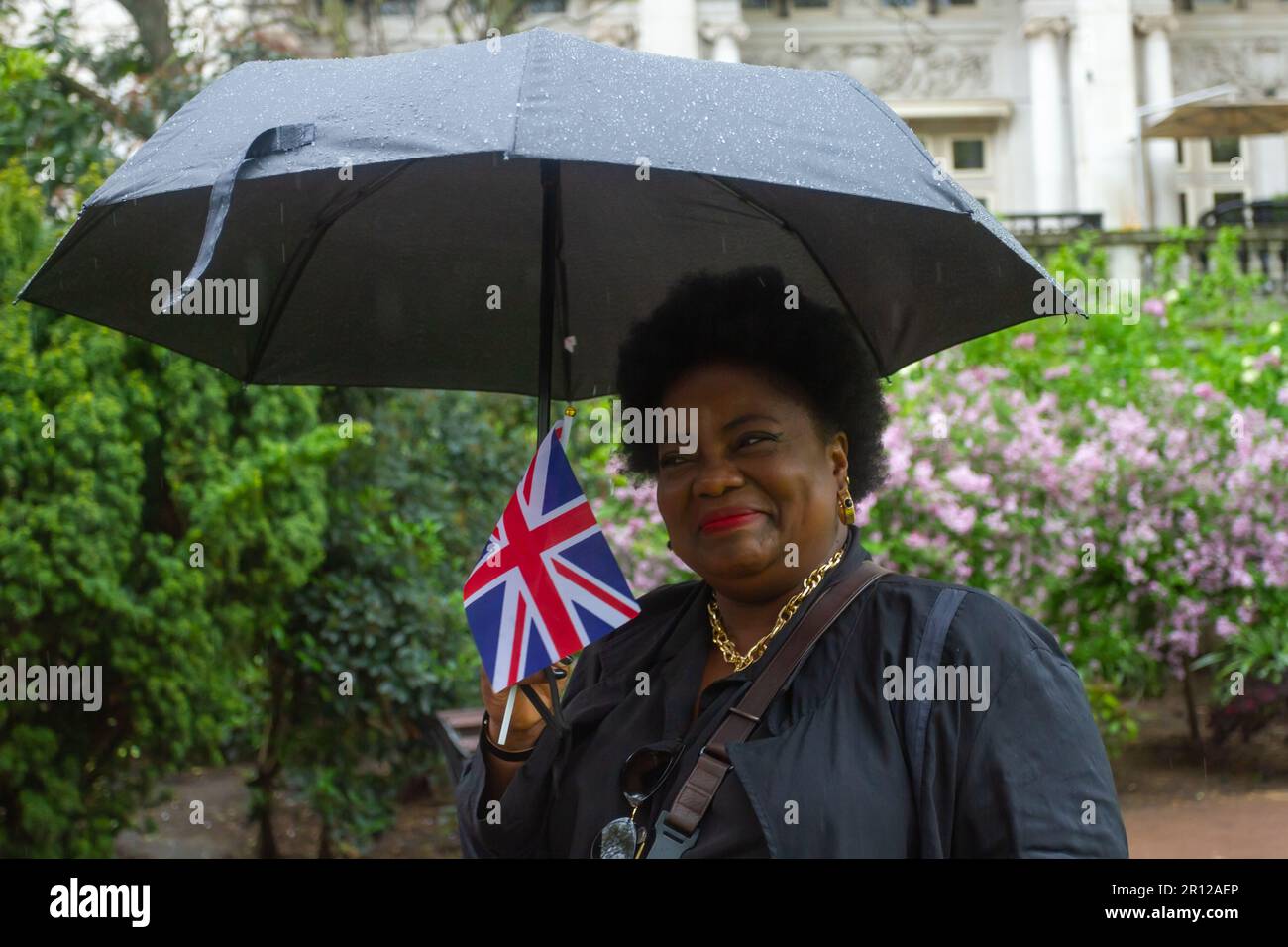 Royaume-Uni Météo Londres, Westminster, Grande-Bretagne. Profil d'une femme adulte souriante dans les jardins de Whitehall lors d'un jour de couronnement pluvieux. Helen Cowles/Alamy. Banque D'Images