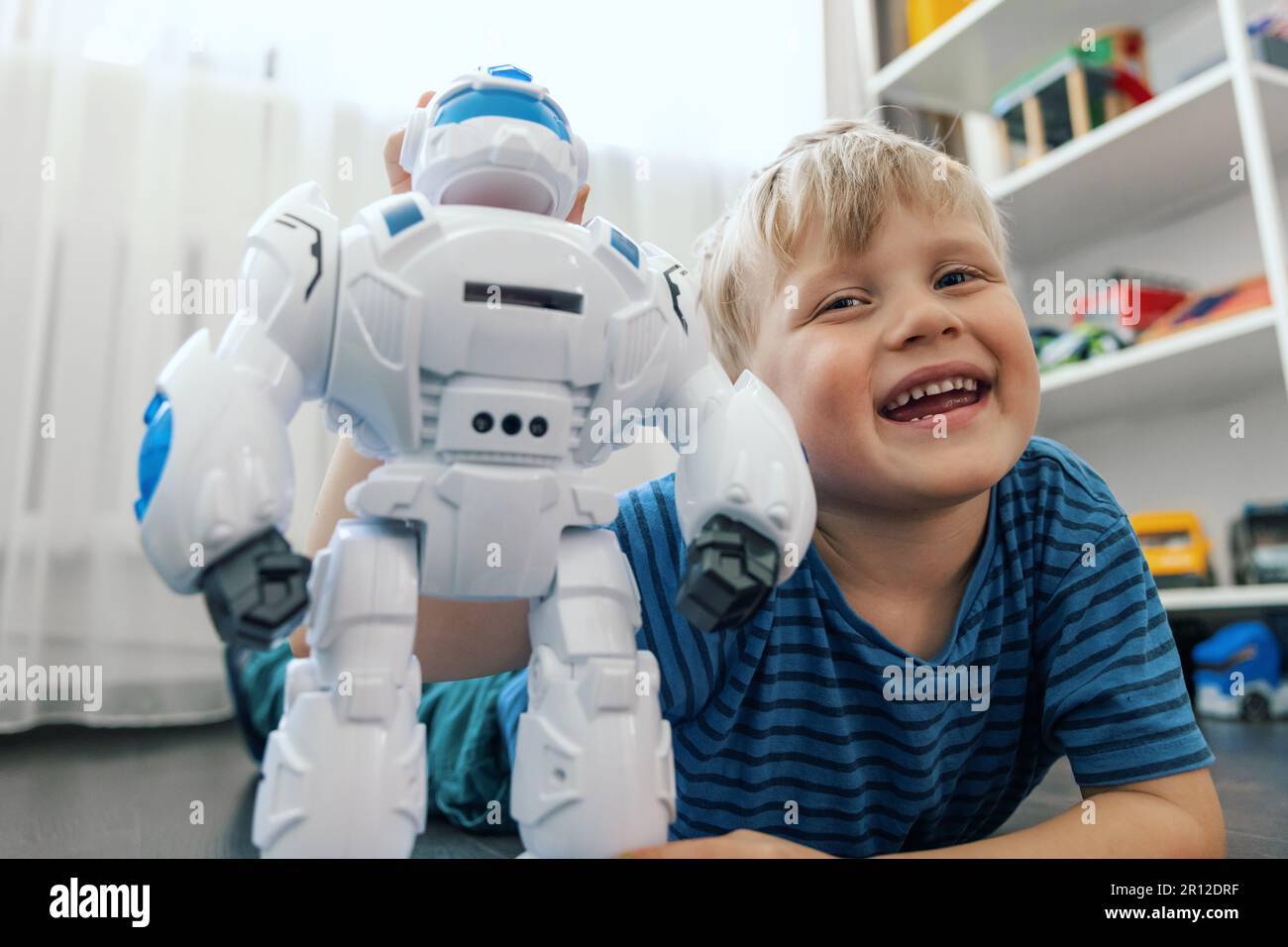 Petit Garçon Blond Jouer Avec Le Robot Jouet À La Maison