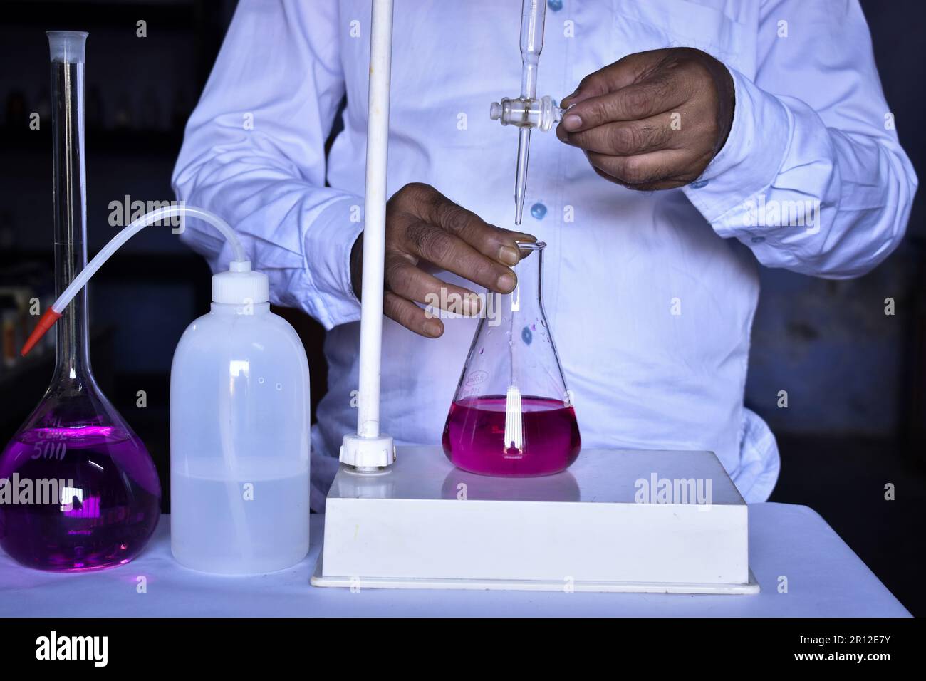 Le scientifique effectue un titrage acido-basique en laboratoire, mesurant précisément la quantité d'acide ou de base nécessaire pour neutraliser une solution. Précision Banque D'Images