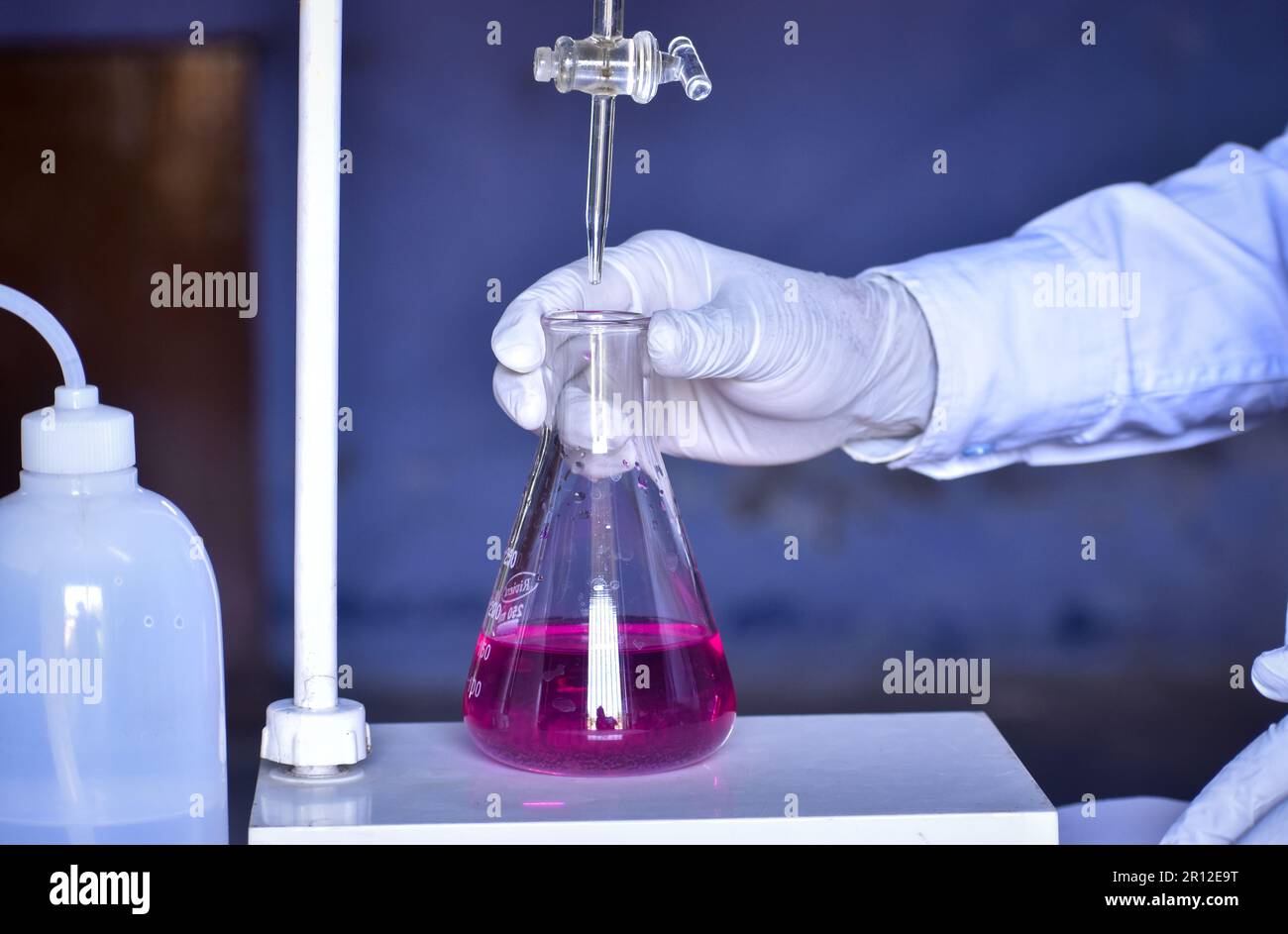 Le scientifique effectue un titrage acido-basique en laboratoire, mesurant précisément la quantité d'acide ou de base nécessaire pour neutraliser une solution. Précision Banque D'Images