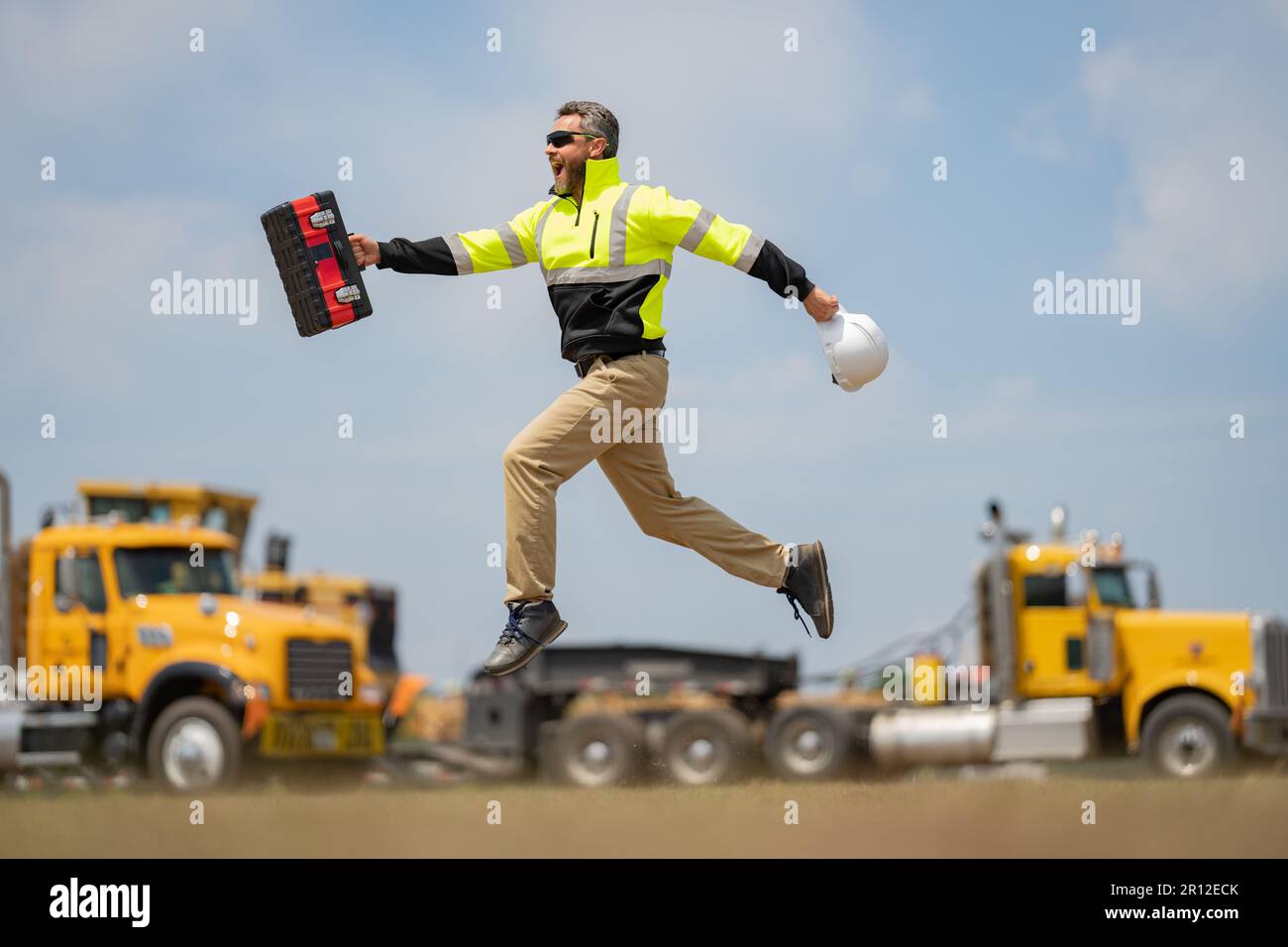 Homme de construction sautant avec un casque. Constructeur en casque ...