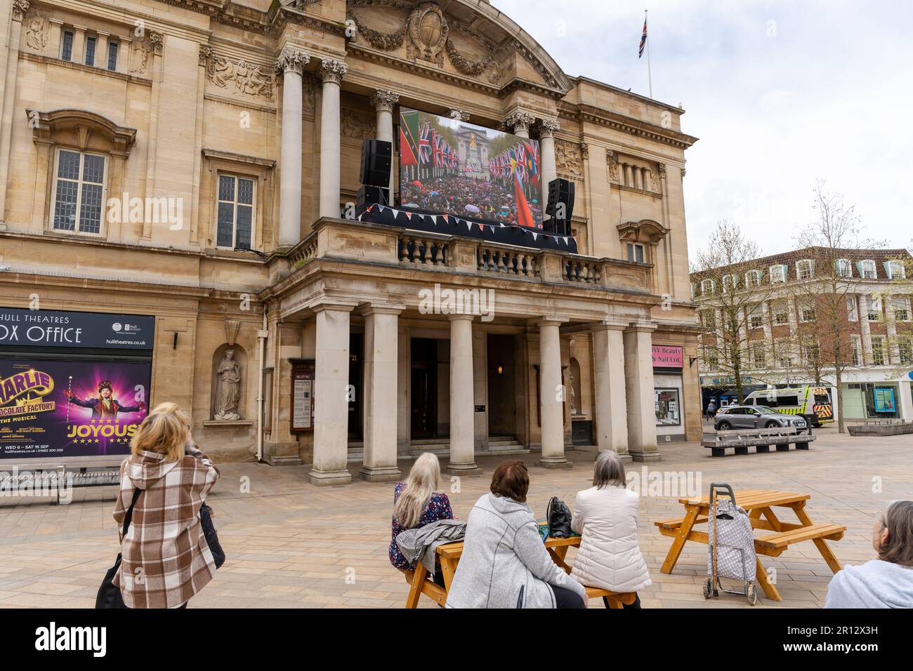 Kingston upon Hull, Royaume-Uni. 6 mai 2023. Les gens qui regardent la diffusion du couronnement du roi Charles III sur la place de la ville. Banque D'Images