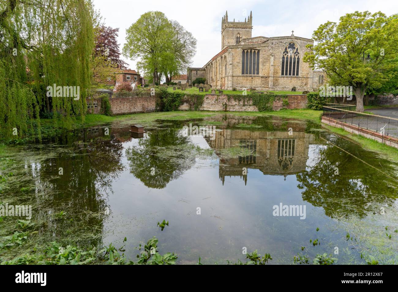 The Beck - un étang artésien alimenté par une source à Barton-upon-Humber, dans le nord du Lincolnshire, au Royaume-Uni, avec l'église anglicane St Mary derrière. Banque D'Images