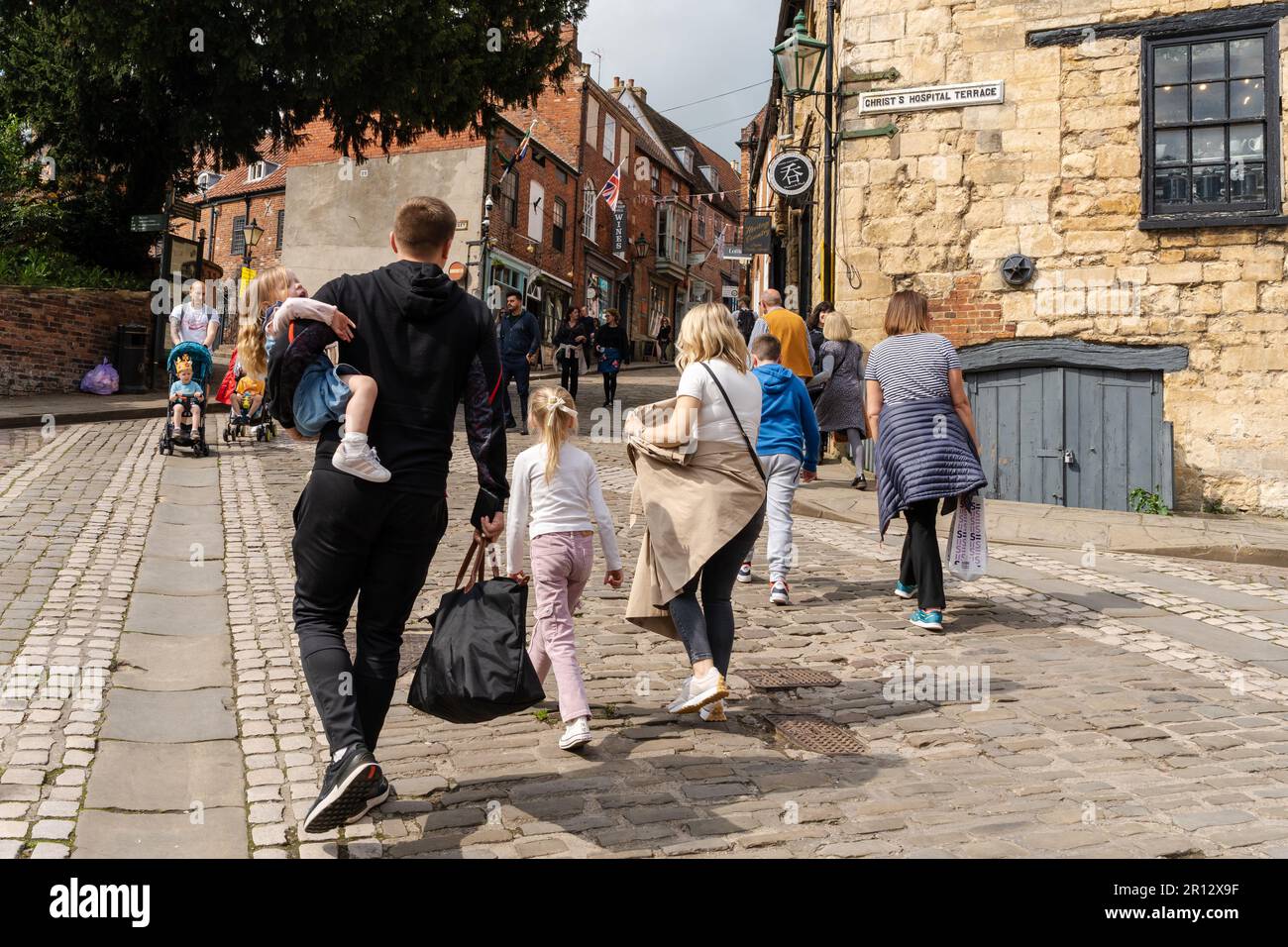 Les gens qui marchent sur Steep Hill, Lincoln, Royaume-Uni, une attraction touristique populaire dans la ville, en raison de ses détaillants indépendants et de charme ancien de worlde. Banque D'Images