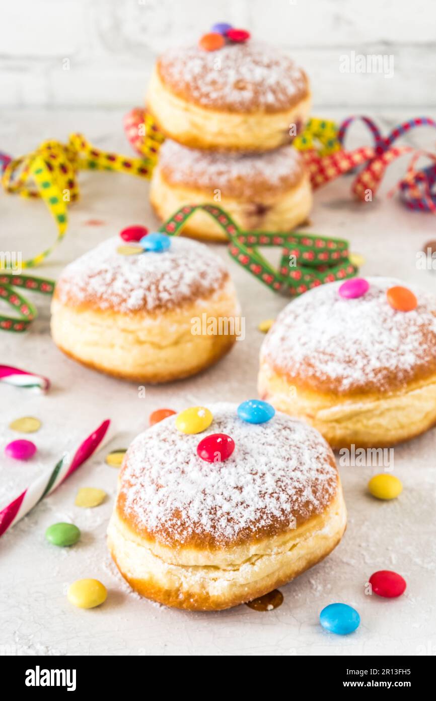 Beignets en poudre de sucre de Carnival, avec banderoles en papier, confetti et grains de chocolat sur fond blanc, vertical Banque D'Images