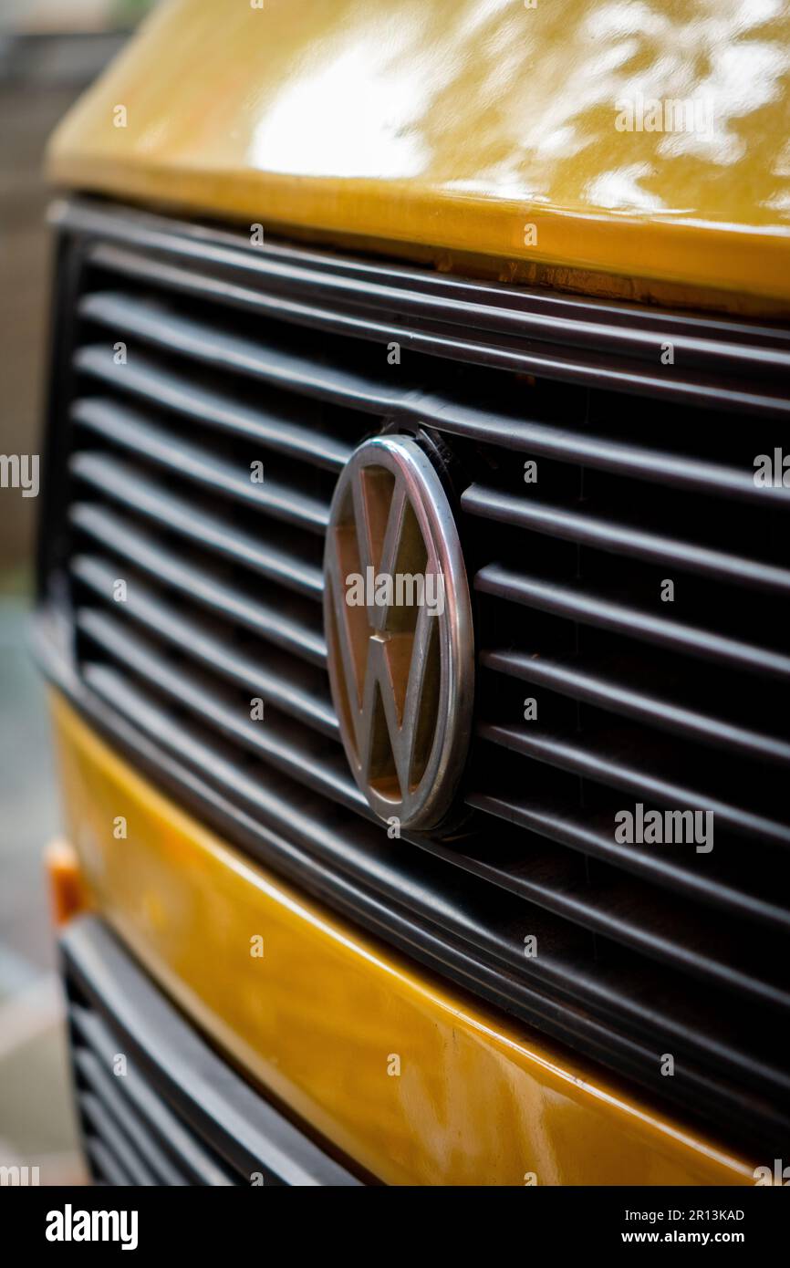 Un gros plan de la calandre avant et du logo d'une voiture jaune Volkswagen. Banque D'Images
