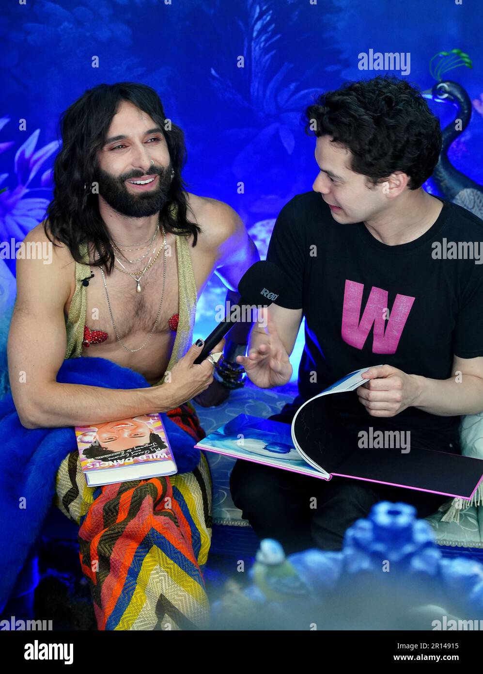 Conchita Wurst s'entretient avec un fan à l'intérieur du site avant la demi-finale du Concours Eurovision de la chanson à la M&S Bank Arena de Liverpool. Date de la photo: Jeudi 11 mai 2023. Banque D'Images