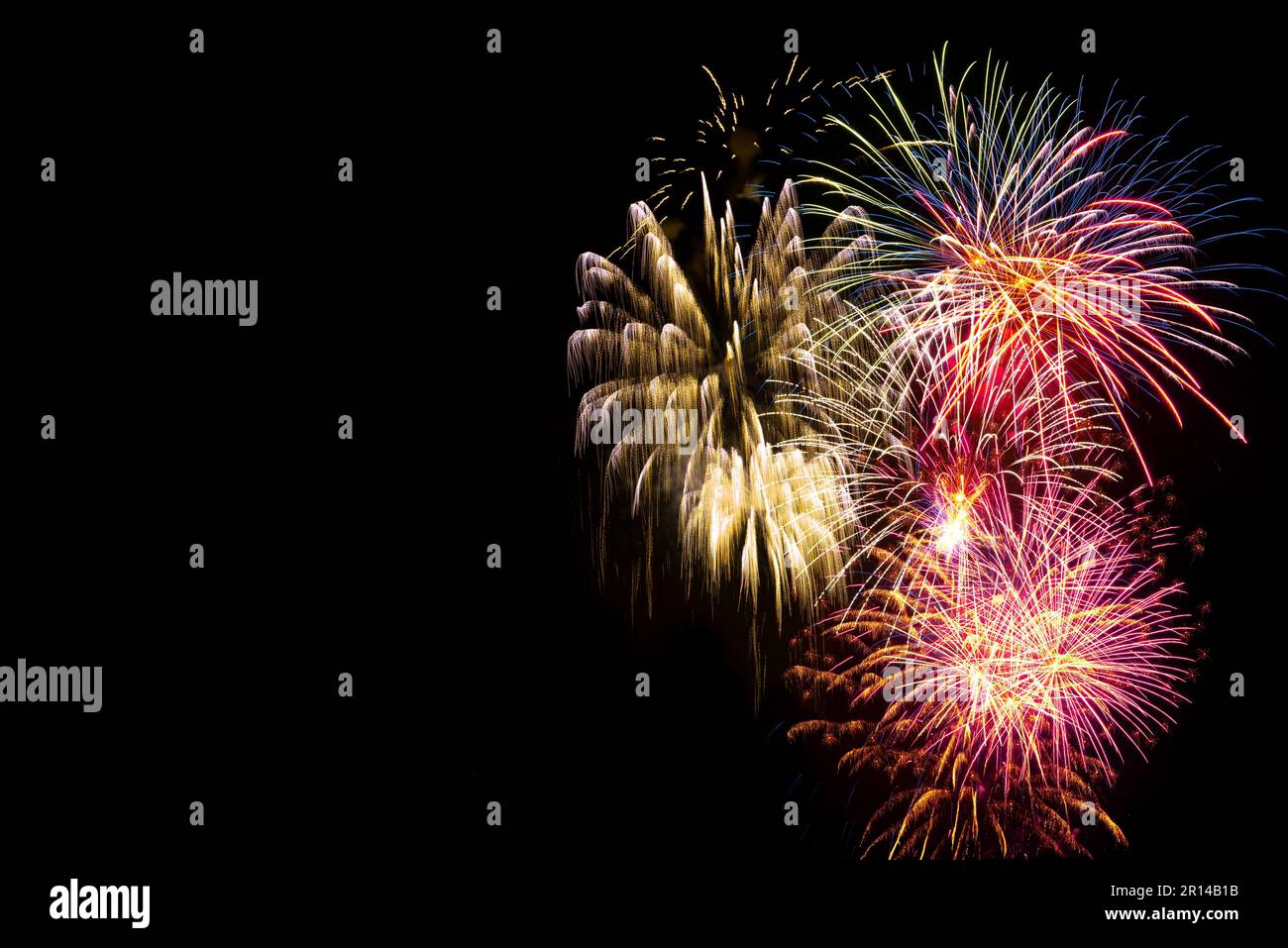Feux d'artifice lumineux et colorés sur fond noir. Contexte pour les fêtes d'anniversaire, les grands événements et les fêtes Banque D'Images