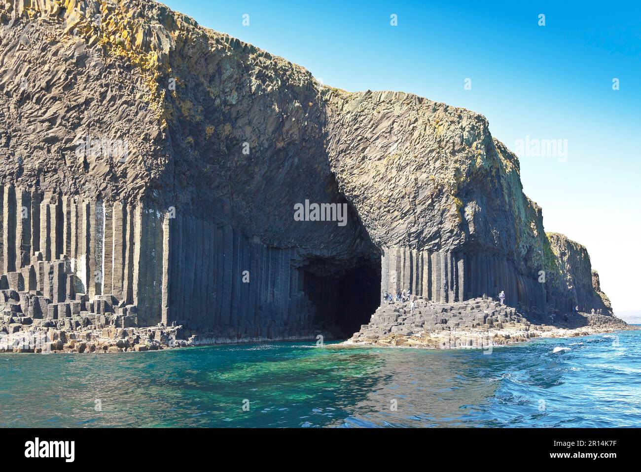 Île de Staffa, Hébrides intérieures, Écosse - 14 juin 2015 : touristes marchant sur les colonnes de basalte sombres du célèbre monument écossais. Banque D'Images