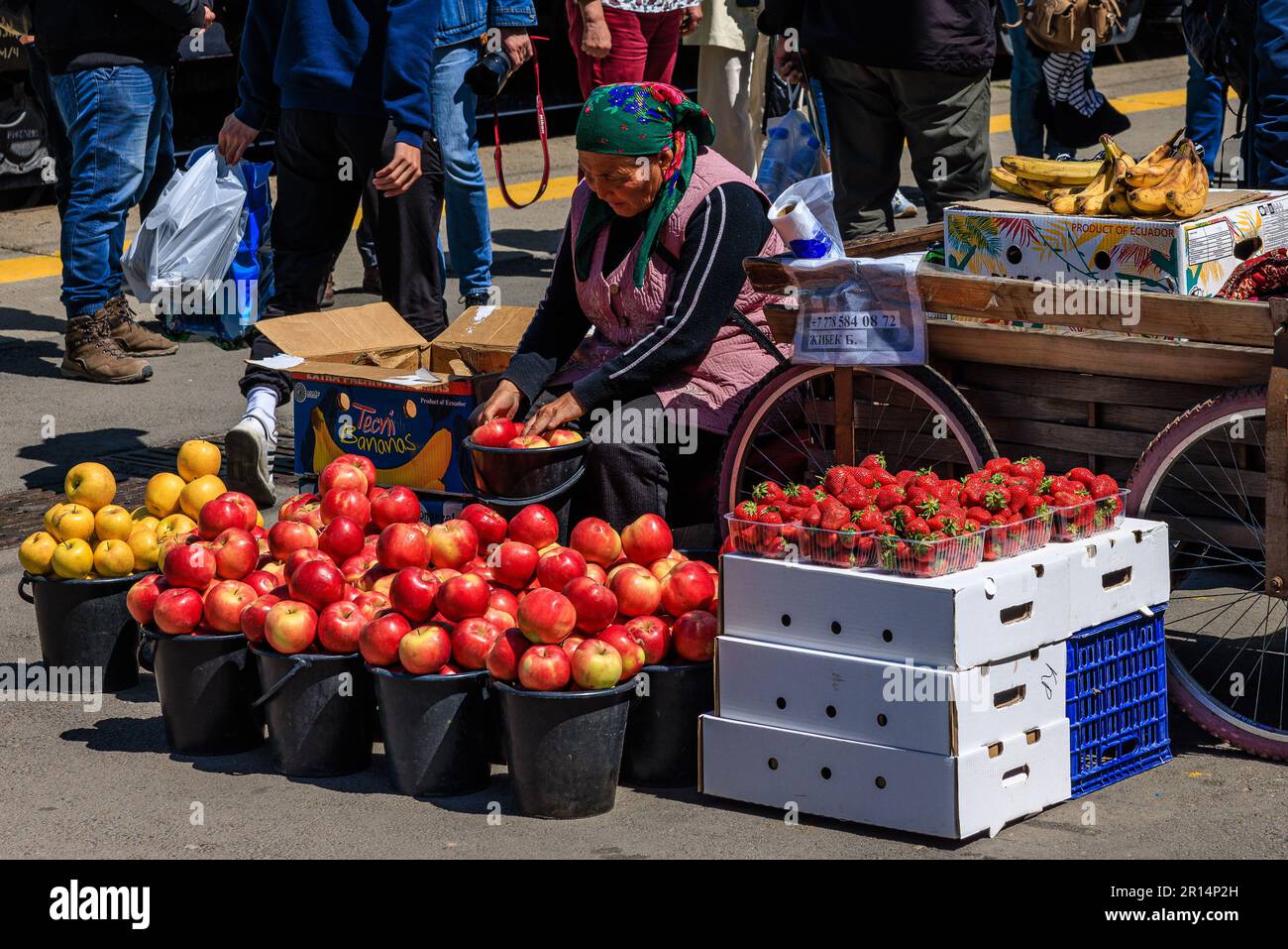 un vendeur de rue a des seaux de pommes en exposition à l'entrée de la gare à almaty kazakhstan, le lieu de naissance de la pomme moderne Banque D'Images