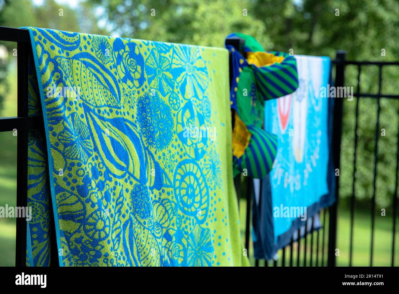 serviettes de plage et floaties suspendues sur une clôture pour sécher Banque D'Images
