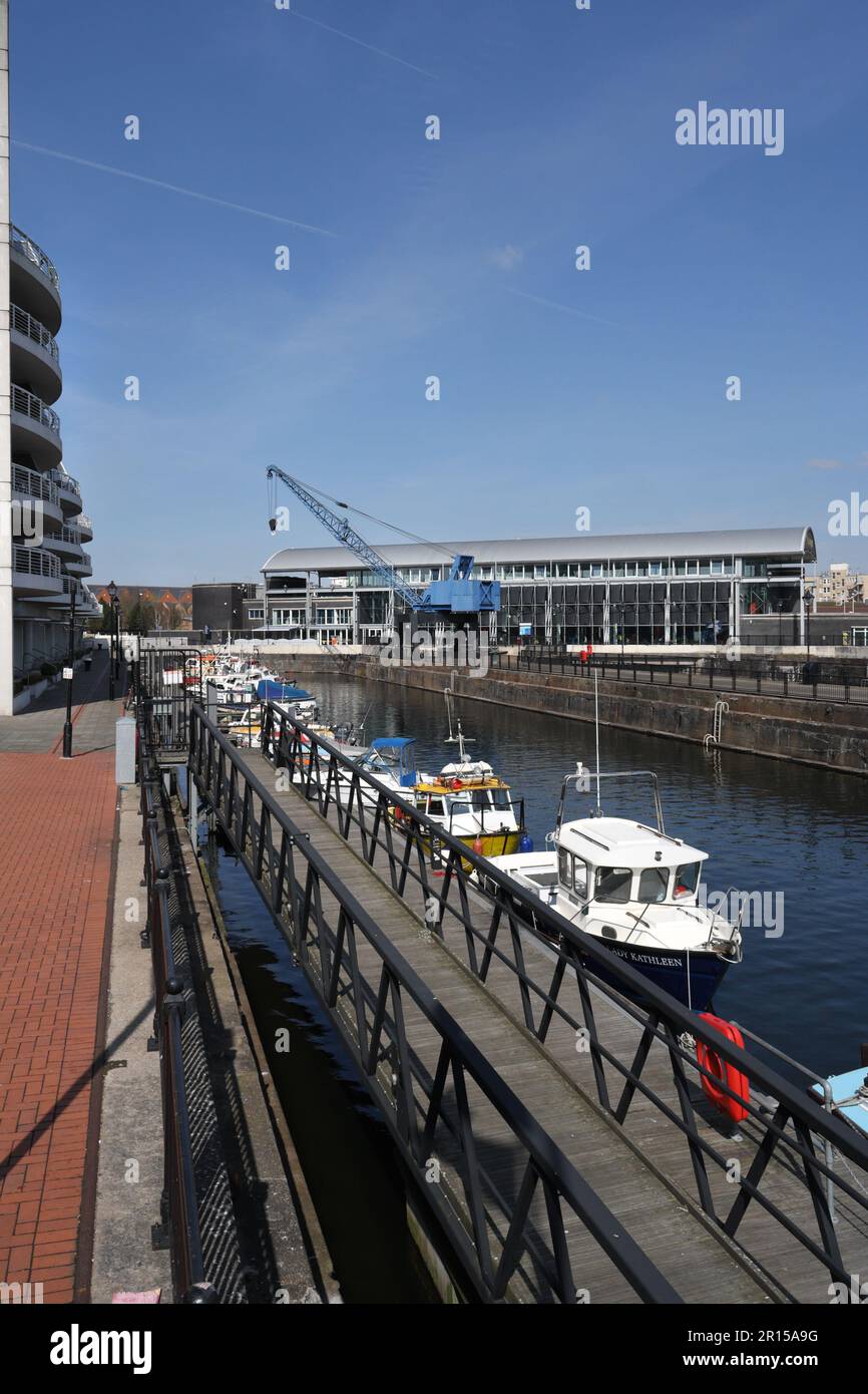 Des bateaux amarrés dans l'ancien quai de gravure, baie de Cardiff, pays de Galles, le long de côté moderne appartements Techniquest bâtiment Banque D'Images