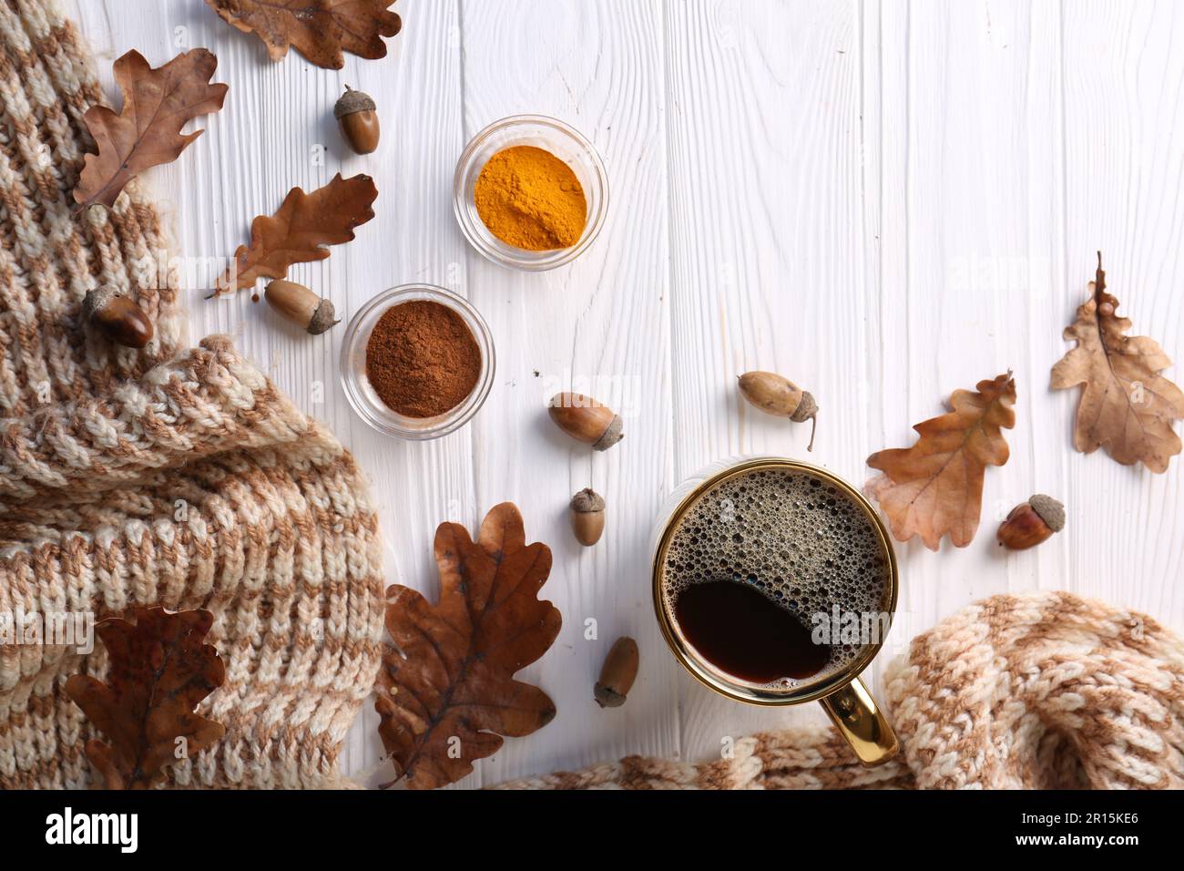 Tasse de boisson chaude, épices, feuilles et écharpe tricotée sur table en  bois blanc, à plat. Atmosphère chaleureuse d'automne Photo Stock - Alamy