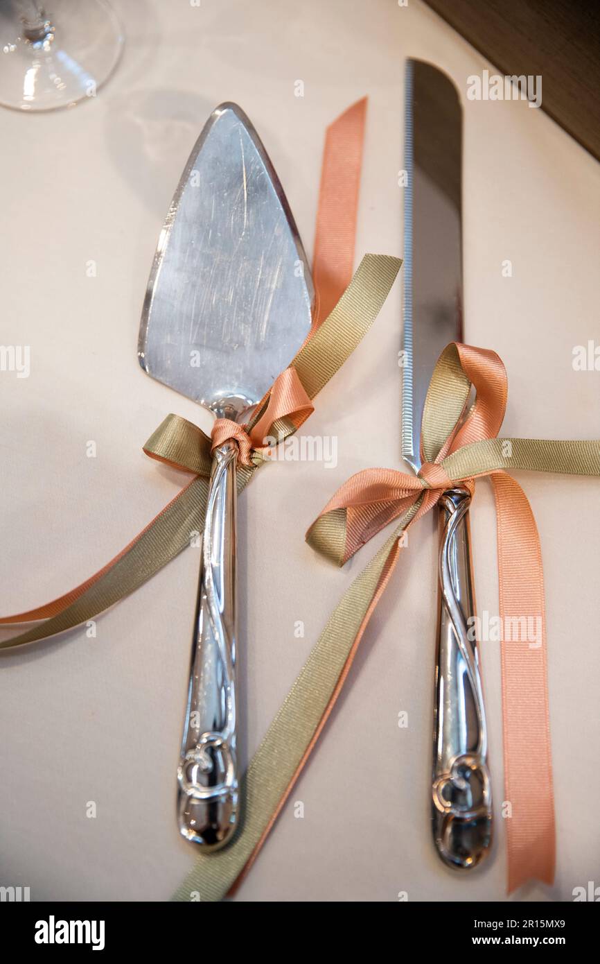 gros plan sur une réception de mariage d'automne avec des serveurs de gâteaux de mariage décorés de coeurs et d'orange pêche et de sauge vert noeuds Banque D'Images