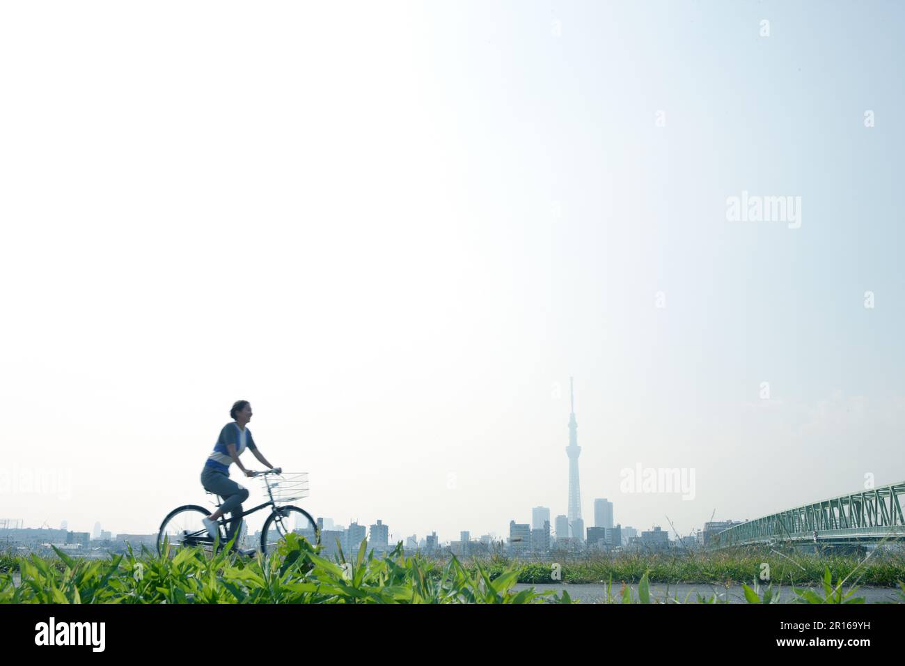 Femme à vélo devant le Sky Tree Banque D'Images