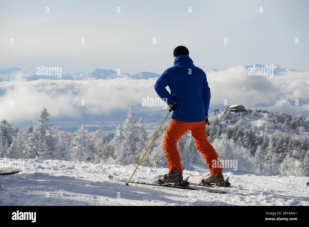 Homme de ski debout dans le paysage de montagne argenté et enneigé Banque D'Images