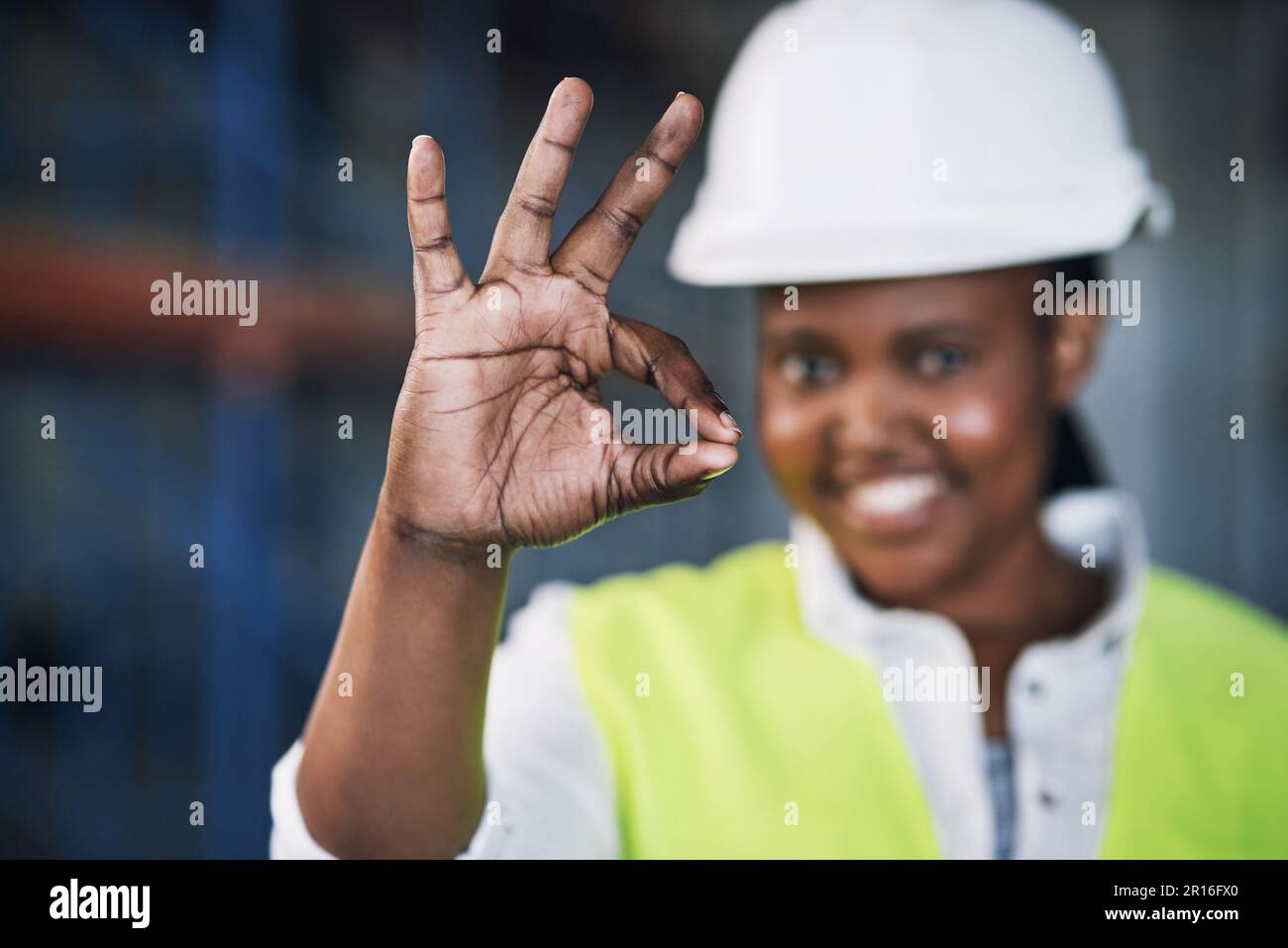 Zéro accident, 100 succès. Portrait d'une jeune femme travaillant montrant un geste correct sur un chantier de construction. Banque D'Images