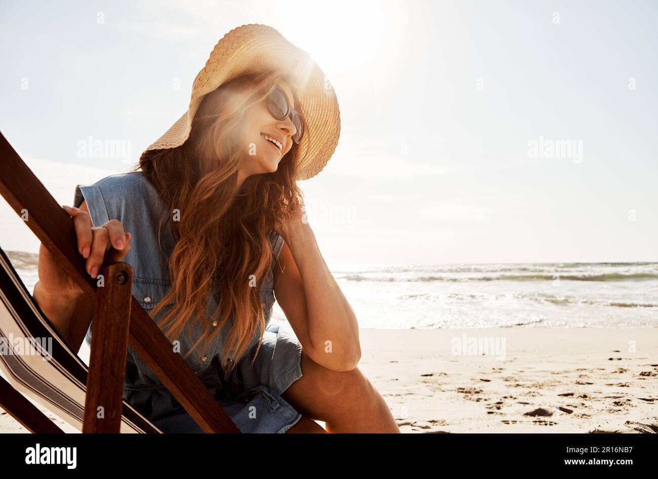 Les shes ont toujours été de type outdoorsy. une jeune femme se détendant sur un transat à la plage. Banque D'Images