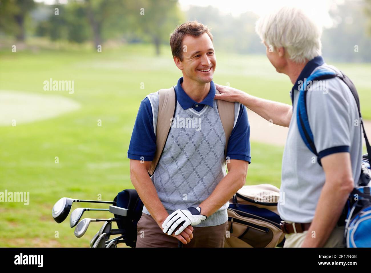 Père et fils discutant sur le terrain de golf. Père et fils ayant une discussion amicale sur le terrain de golf. Banque D'Images