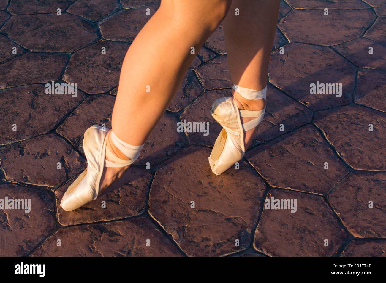 Sur les pieds de la pointe ballerine à l'heure d'or sur le sentier de la roche Banque D'Images