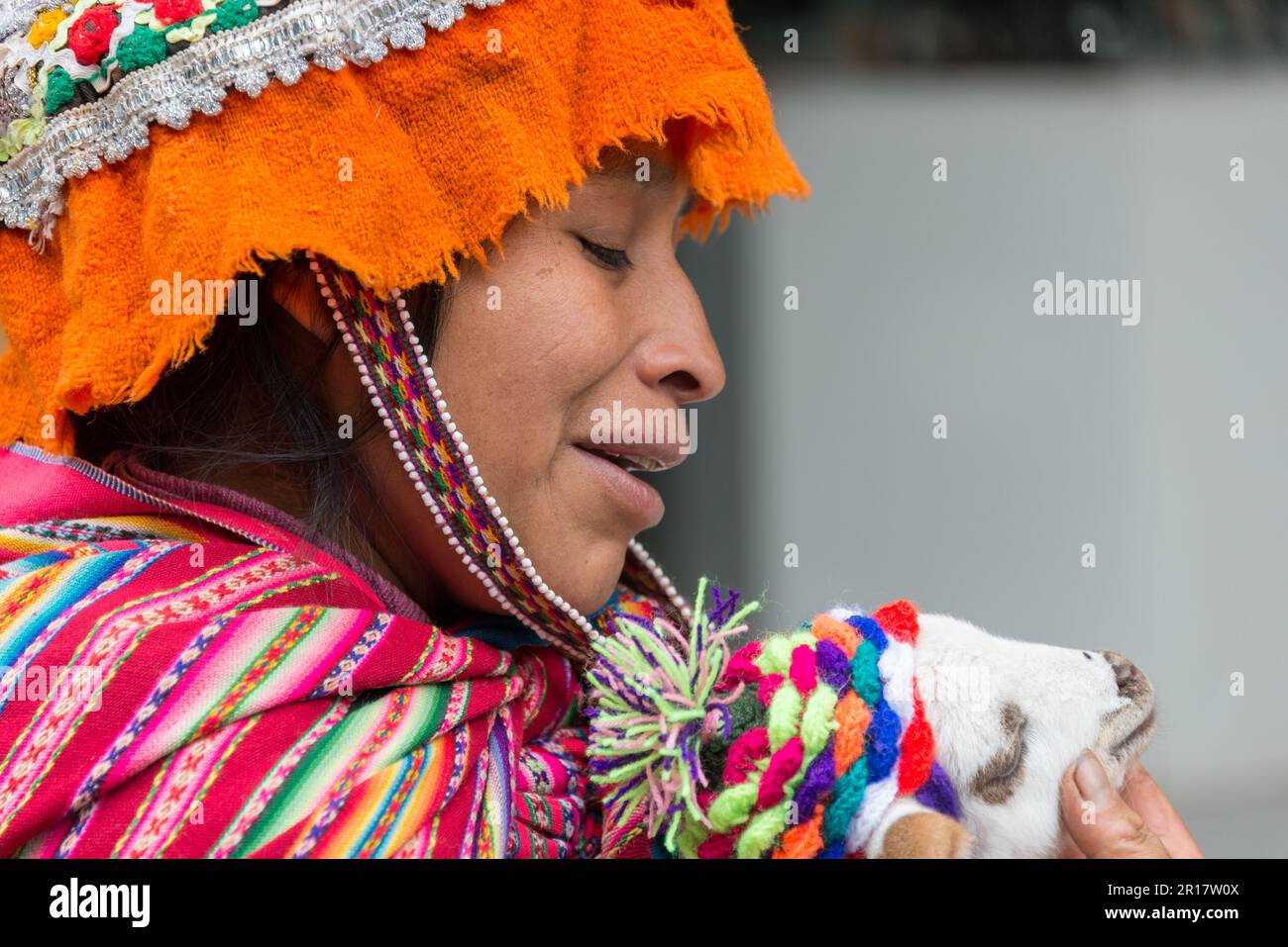 Jeune femme en robe traditionnelle tenant une chèvre à Pisac, Pérou Banque D'Images