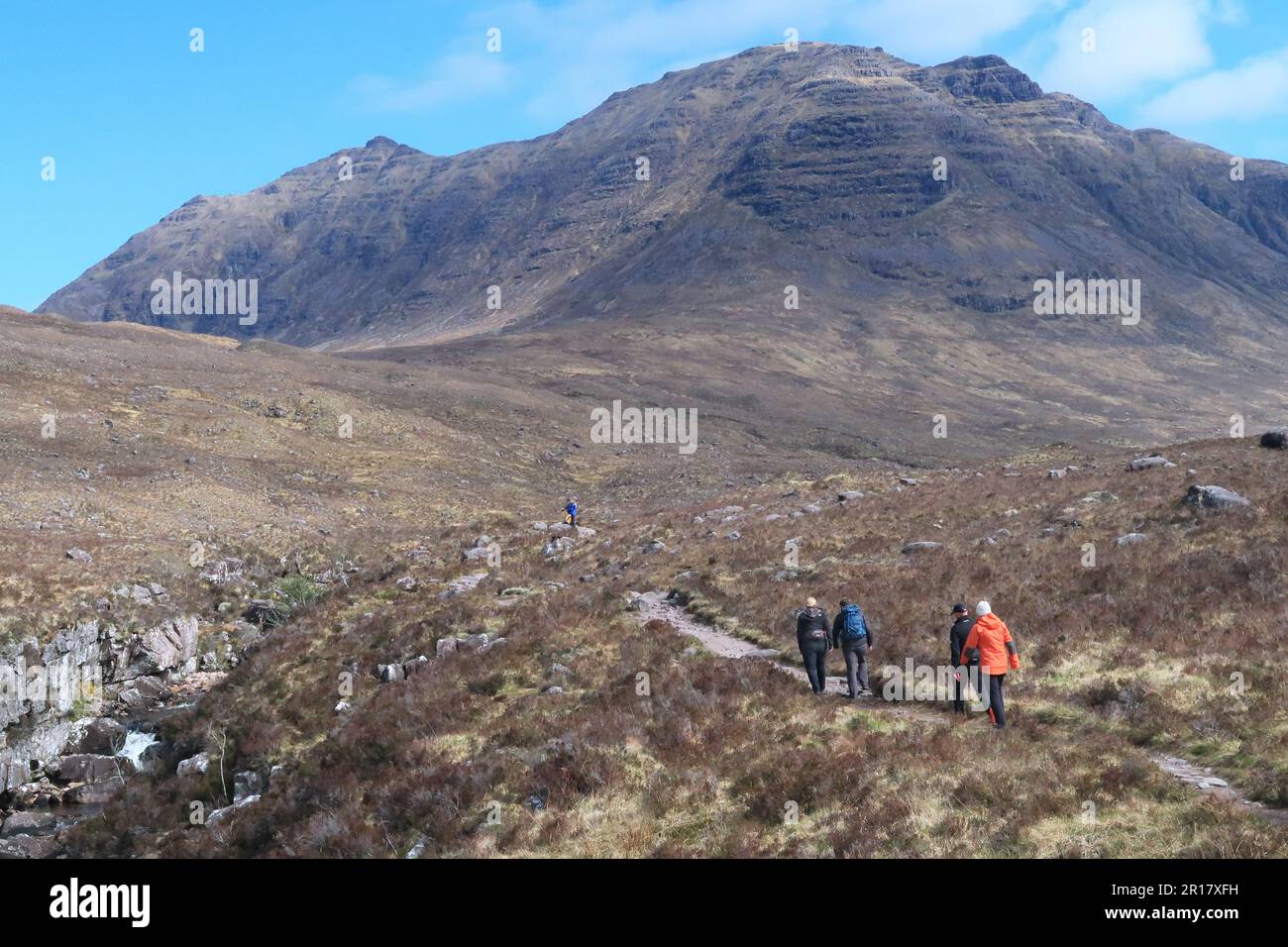 Scottish Highlands: Randonneurs dans la vallée de Coire MhicNobaill, près de Torridon. Montre le pic dramatique de Beinn Dearg en arrière-plan. Banque D'Images
