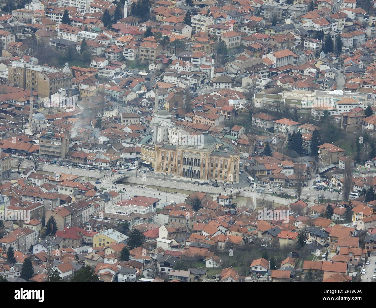 Vue aérienne sur un paysage urbain avec des bâtiments aux toits rouges et une végétation luxuriante le long des routes Banque D'Images