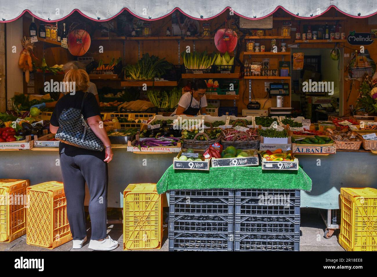 Femme achetant des fruits et légumes frais dans une épicerie donnant sur la rue en été, Venise, Vénétie, Italie Banque D'Images