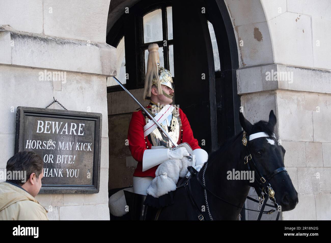 Whitehall, Londres, Royaume-Uni. 28th avril 2023. Un gardien de la vie du roi a monté deux sentinelles montées en service à la parade de la garde du cheval à Whitehall. En dépit de signes clairs indiquant aux visiteurs et aux touristes que les chevaux peuvent se faire des coups de pied ou des morsures, les touristes insistent toujours pour se tenir juste à côté des chevaux sur la garde. Il y a eu récemment un certain nombre d'occasions où un garde a dû crier un touriste pour revenir. Crédit : Maureen McLean/Alay Banque D'Images