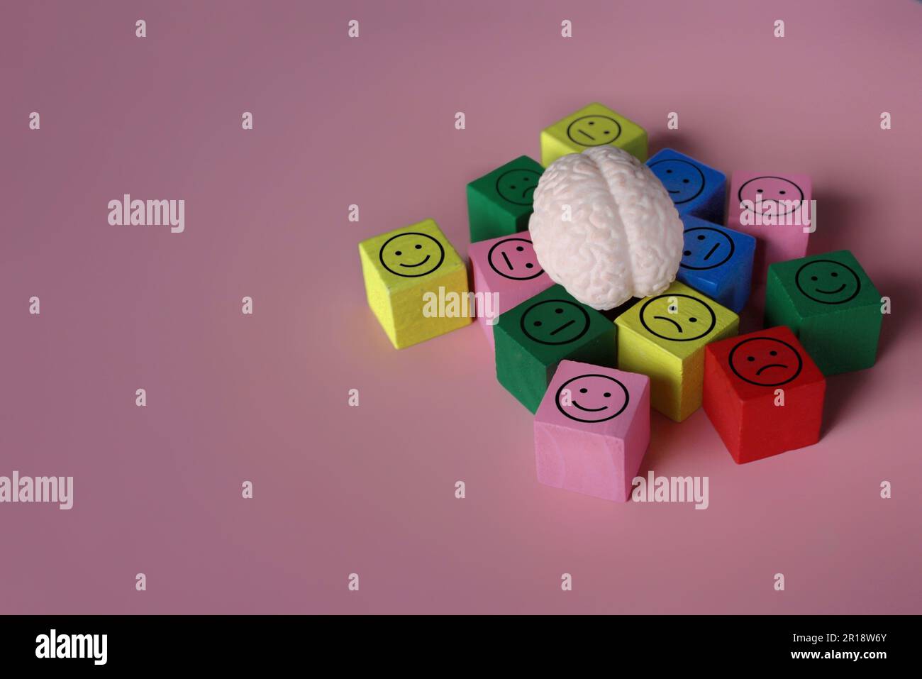 Cerveau humain avec une icône heureuse, neutre et triste. Santé mentale, sautes d'humeur, concept de trouble bipolaire. Banque D'Images