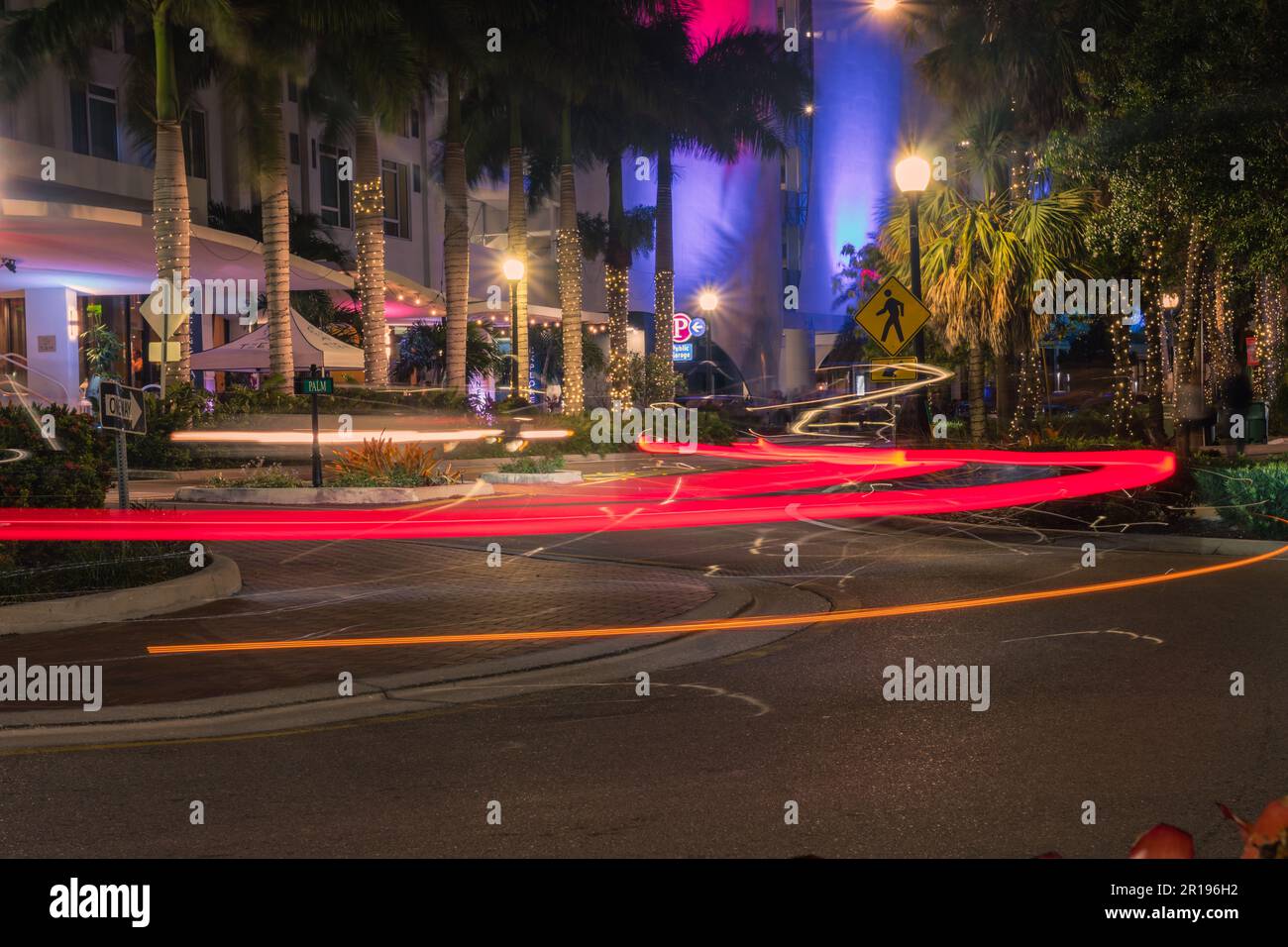 Sarasota, FL, US-10 avril 2023 : intersection colorée la nuit dans le quartier des divertissements du centre-ville avec des sentiers de lumière rouge. Banque D'Images