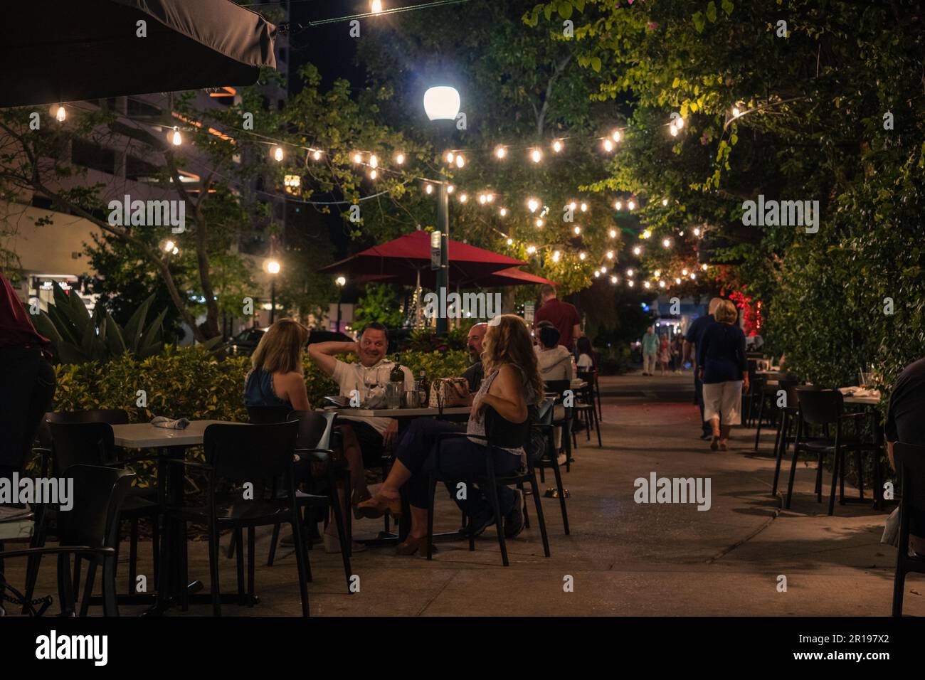 Sarasota, FL, US-20 avril 2023: Les gens mangent dans un restaurant en plein air le soir dans le quartier historique du centre-ville. Banque D'Images