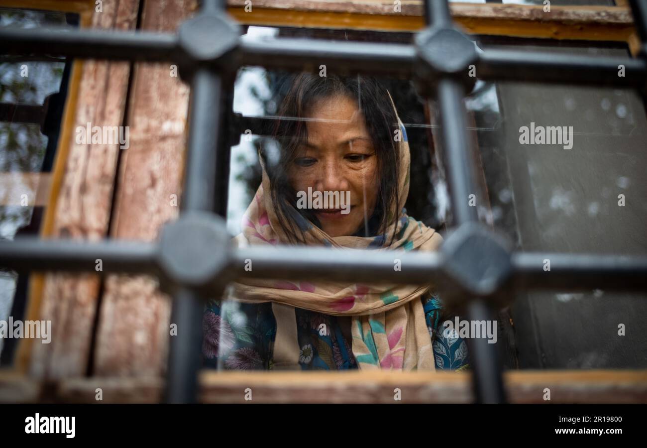 Une femme asiatique (vietnamienne), portant un foulard, derrière une fenêtre à la mosquée Suleymaniye du 16th siècle dans le château d'Alanya, en Turquie, regarde dans c Banque D'Images