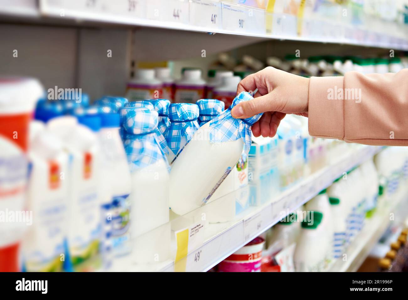 Boire du yogourt dans les mains d'un acheteur dans un magasin Banque D'Images