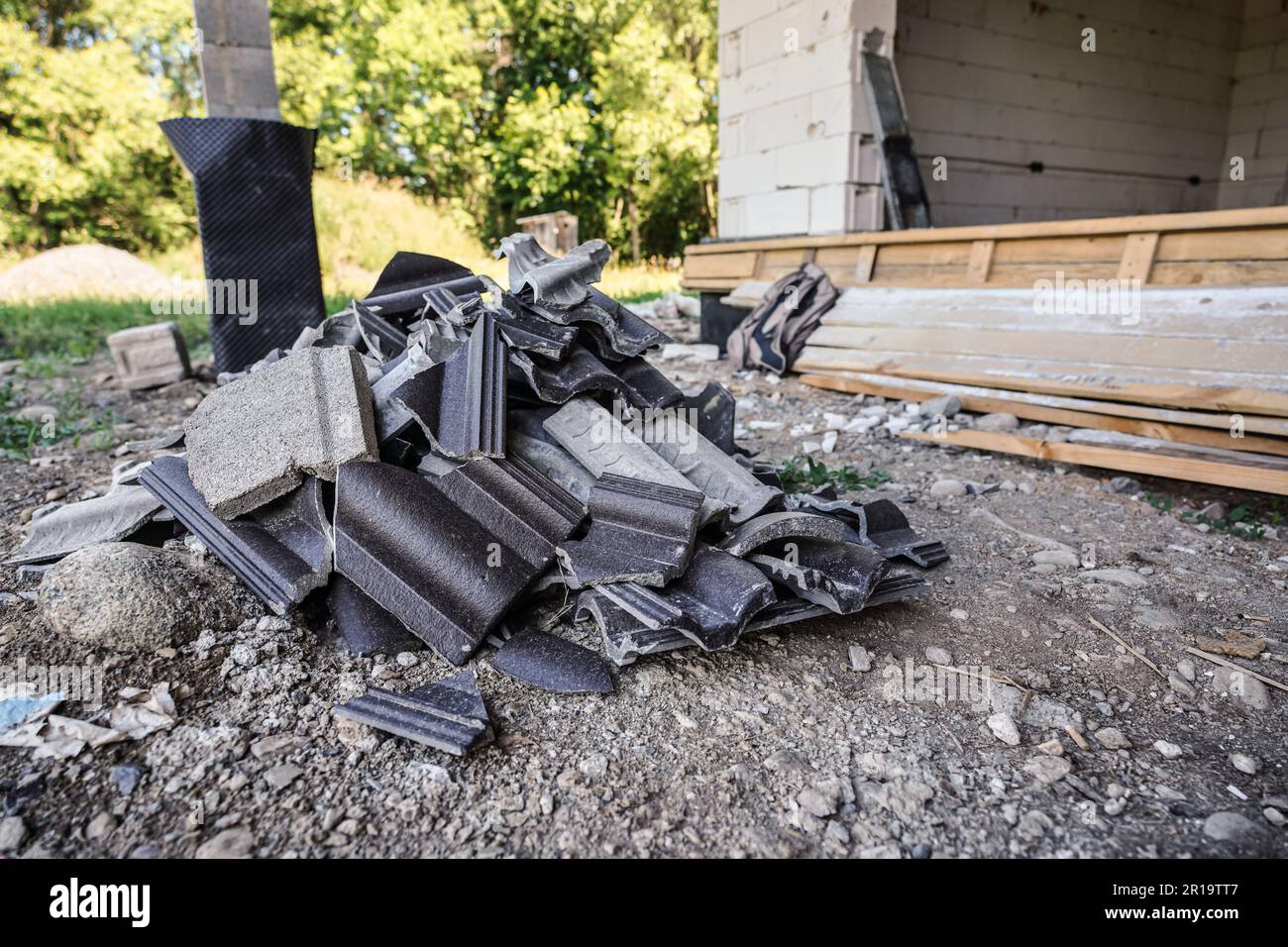Déchets de débris industriels - restes de tuiles de toit sur le sol sur le chantier de construction Banque D'Images
