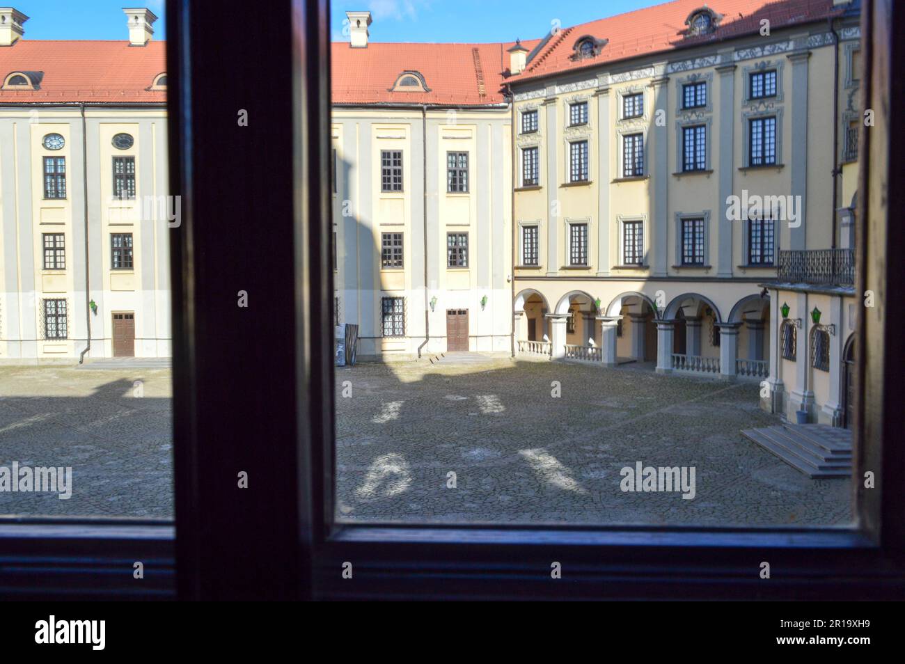 La vue de la fenêtre avec les cadres sur les beaux bâtiments historiques médiévaux européens de faible hauteur jaune avec un toit en tuiles rouges pignon et rectan Banque D'Images