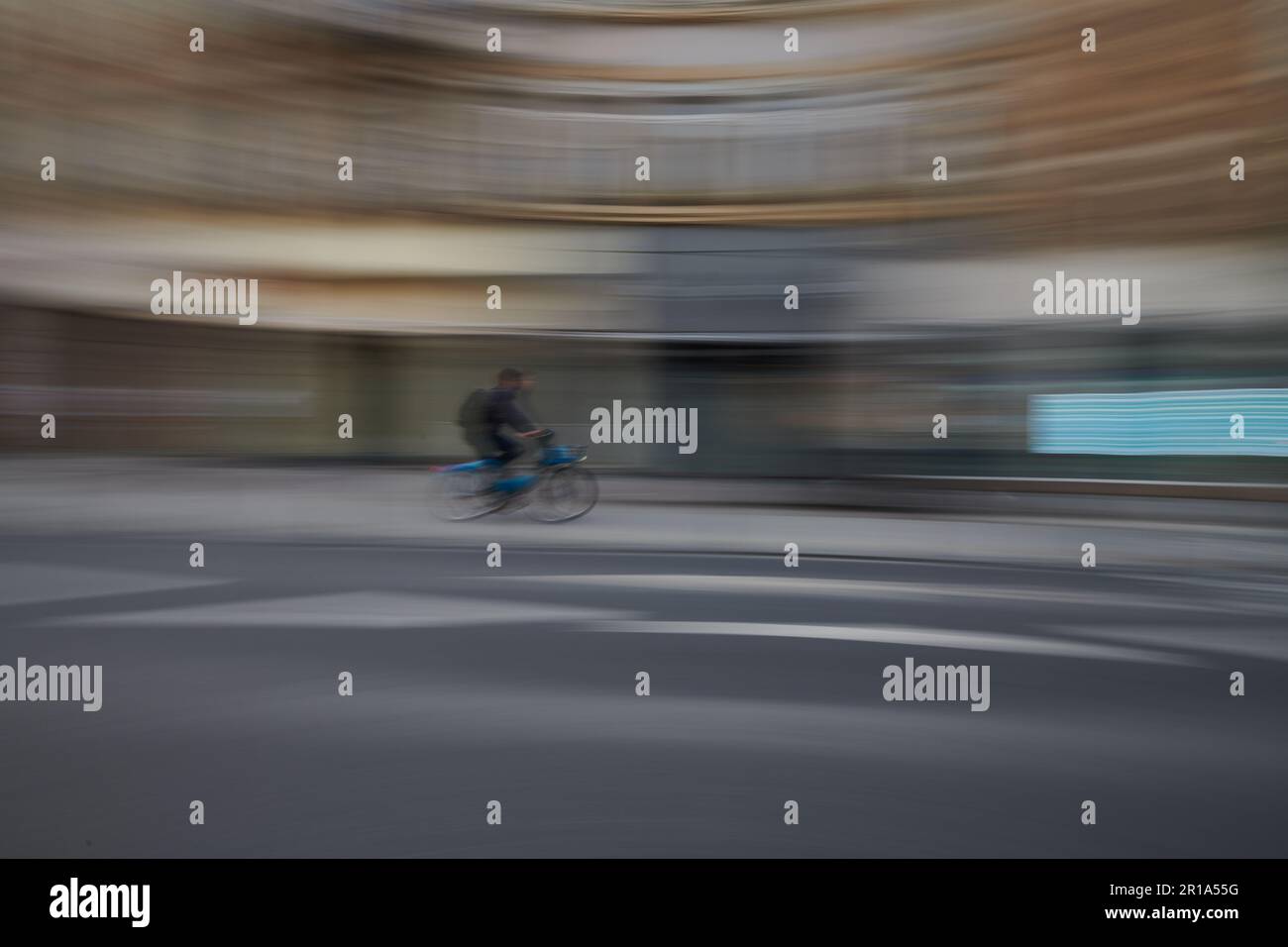 Cycliste passant dans le centre-ville. Utilisez une exposition longue pour créer un effet de flou Banque D'Images