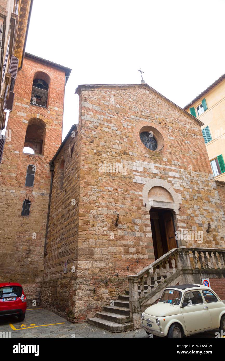 Sienne, Italie - APR 7, 2022: Petite église en brique et pierre et vue sur la rue depuis la ville italienne historique de Sienne en Toscane. Banque D'Images