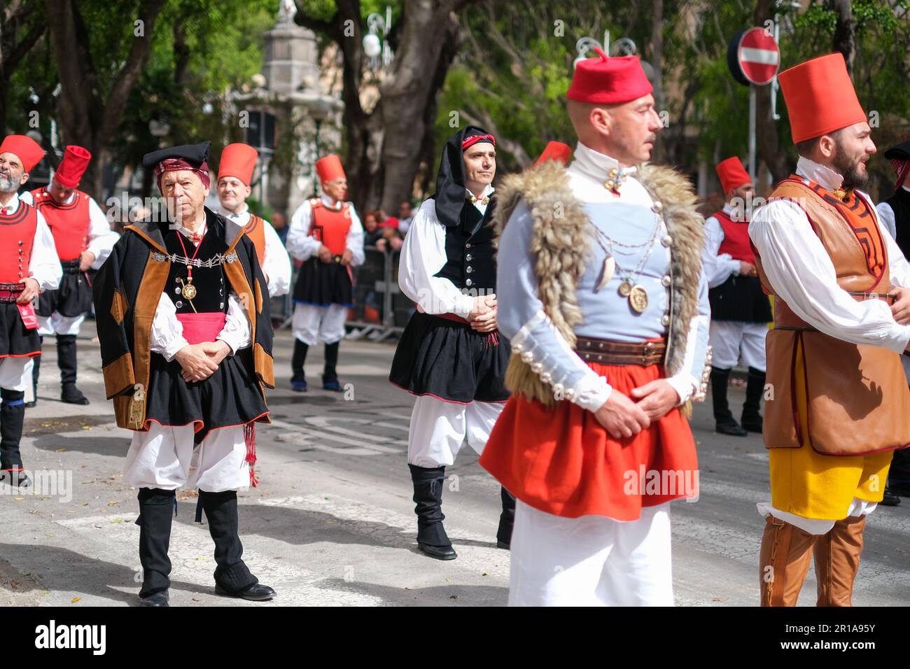 Des hommes sardes vêtus de costumes traditionnels folkloriques, avec des éléments uniques représentant la région d'où ils viennent, se joignent au festival de la fête de Saint Efisio Banque D'Images